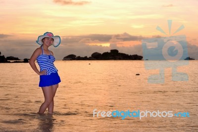 Girl On The Beach At Sunrise Over The Sea Stock Photo