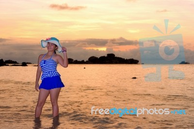 Girl On The Beach At Sunrise Over The Sea Stock Photo