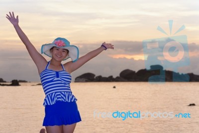 Girl On The Beach At Sunrise Over The Sea Stock Photo