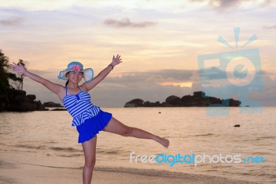 Girl On The Beach At Sunrise Over The Sea Stock Photo