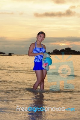 Girl On The Beach At Sunrise Over The Sea Stock Photo