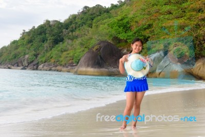 Girl On The Beach At Sunrise Over The Sea Stock Photo