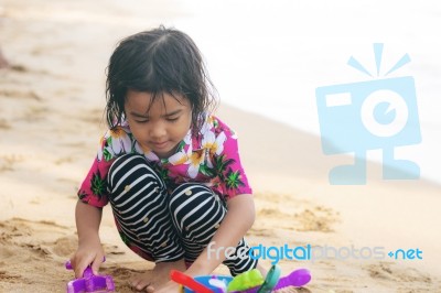 Girl Playing Toy On Beach Stock Photo