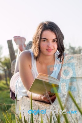 Girl Reading Book Outdoors Stock Photo