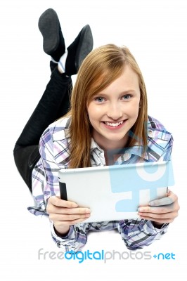 Girl Relaxing On Studio Floor And Browsing Her New Tablet Stock Photo