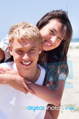 Girl Riding On Guy At Beach Stock Photo