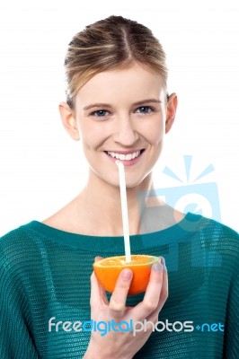 Girl Sipping Orange Juice Through Straw Stock Photo