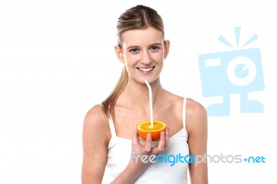 Girl Sipping Orange Juice Through Straw Stock Photo