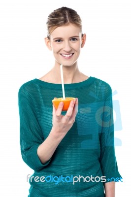 Girl Sipping Orange Juice Through Straw Stock Photo