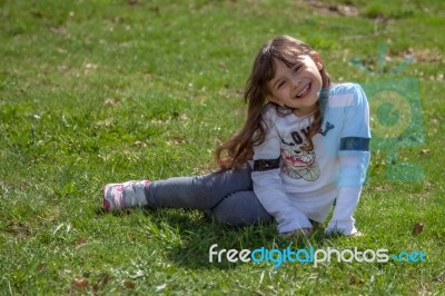 Girl Sitting In The Meadow Stock Photo