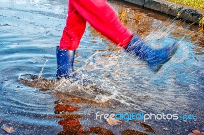 Girl Standing In A Puddle Of Water Splashes Stock Photo