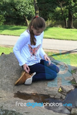 Girl Thinking On A Rock Stock Photo