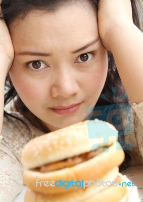 Girl Thinking With Hamburger Stock Photo