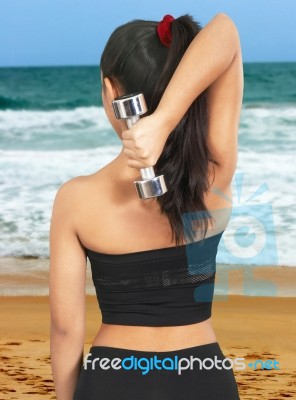 Girl Using Dumbbell To Exercise Stock Photo