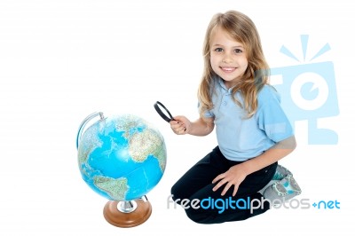 Girl Watching Globe Through Magnifying Glass Stock Photo