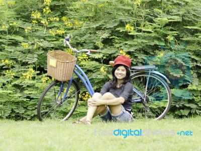 Girl With A Bicycle Rests On A Grass Stock Photo