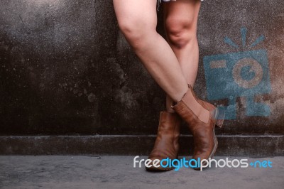 Girl With Boots At Wall Stock Photo