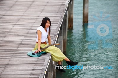 Girl With Guitar On Wooden Bridge Stock Photo