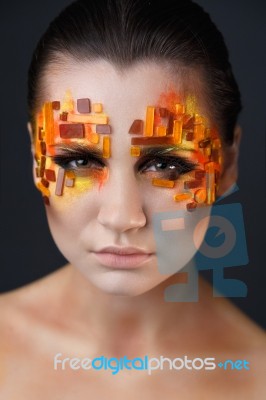 Girl With Orange And Red Rhinestones On Her Face Stock Photo