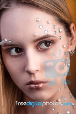 Girl With White And Pearl Rhinestones On Her Face Stock Photo