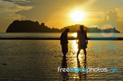 Girls And Boy On The Hat Sai Ri Beach During Sunrise Stock Photo