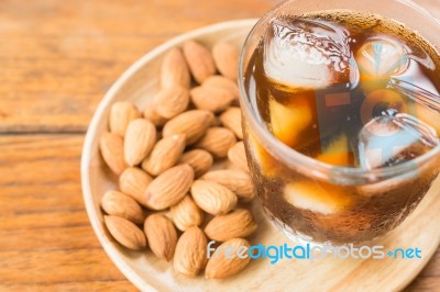 Glass Of Black Iced Coffee With Almond Grain Stock Photo