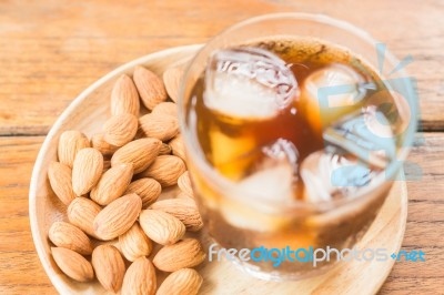 Glass Of Black Iced Coffee With Almond Grain Stock Photo