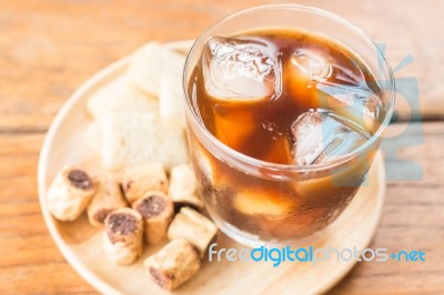 Glass Of Black Iced Coffee With Some Snack Stock Photo