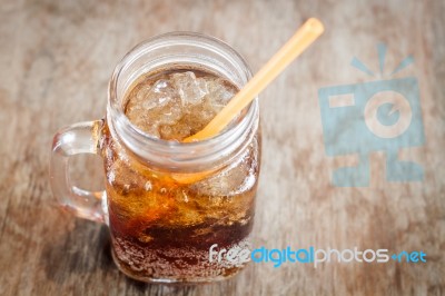 Glass Of Cola With Ice On Wooden Table Stock Photo