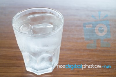 Glass Of Cold Water On Wooden Table Stock Photo