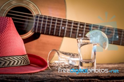 Glass Of Vodka And Classical Guitar With Red Hat Stock Photo