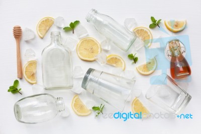 Glasses And Bottle For Drinks With Lemon Slices, Mint And Honey Stock Photo