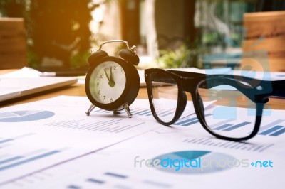 Glasses And Clock On The Business Paper. Report Chart Stock Photo