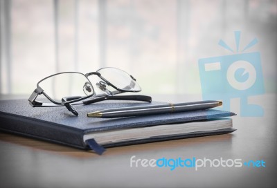 Glasses And Pen On A Book Stock Photo