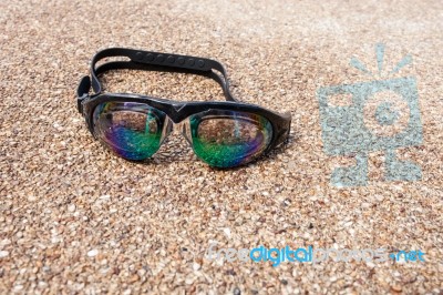 Glasses For Swimming On A Cement Floor With Small Stone Near Swi… Stock Photo