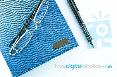 Glasses on Notebook With Pen Stock Photo