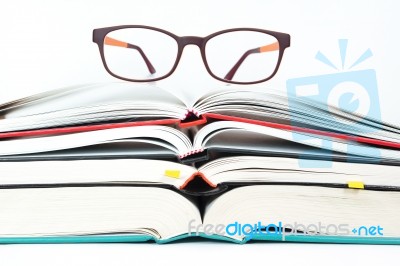 Glasses On Stack Of Open Books Stock Photo