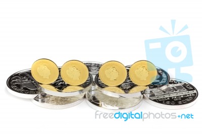 Gold Coins Standing On Silver Coins Stock Photo