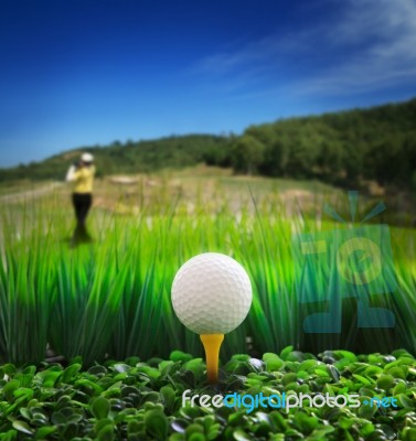 Golf Ball On Tee With Beautiful Golf Course Background Stock Photo