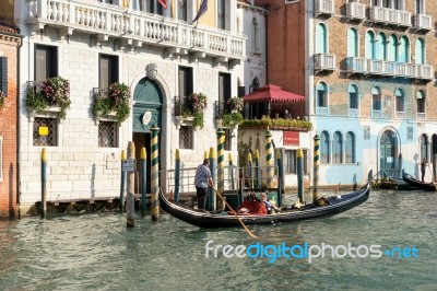 Gondolier Ferrying A Passenger Along The Grand Canal Stock Photo