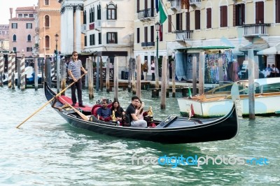 Gondolier Ferrying People In Venice Stock Photo