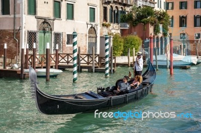 Gondolier Ferrying People In Venice Stock Photo