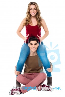 Gorgeous Girl Sitting On Her Boyfriend's Shoulder Stock Photo