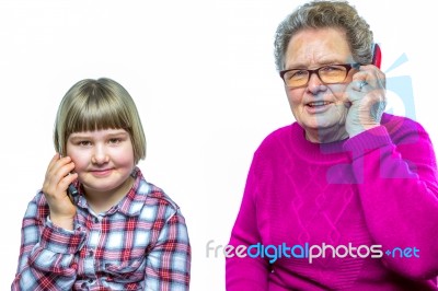 Grandmother And Granddaughter Phoning With Mobile Phone Stock Photo