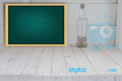 Green Chalkboard And Bottle Seashell In White Room Stock Photo