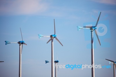 Green Renewable Energy Concept - Wind Generator Turbines In Sky Stock Photo