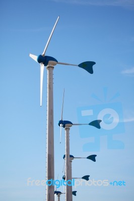 Green Renewable Energy Concept - Wind Generator Turbines On Blue… Stock Photo