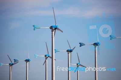 Green Renewable Energy Concept - Wind Generator Turbines On Blue… Stock Photo