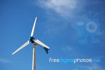 Green Renewable Energy Concept - Wind Generator Turbines On Blue… Stock Photo