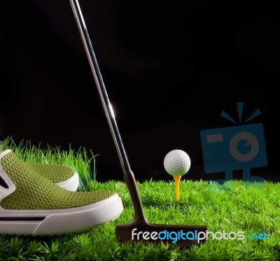 Green Shoe And Golf Ball On Field Stock Photo